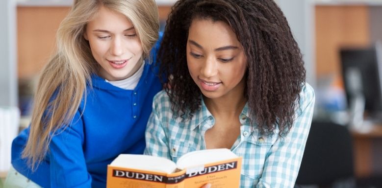 Zwei Schülerinnen lesen im Duden