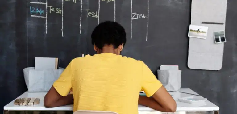 Schüler mit gelbem T-Shirt schreibt einen Test