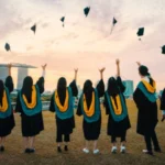 Eine Gruppe von Frauen wirft ihren akademischen Hut in die Luft