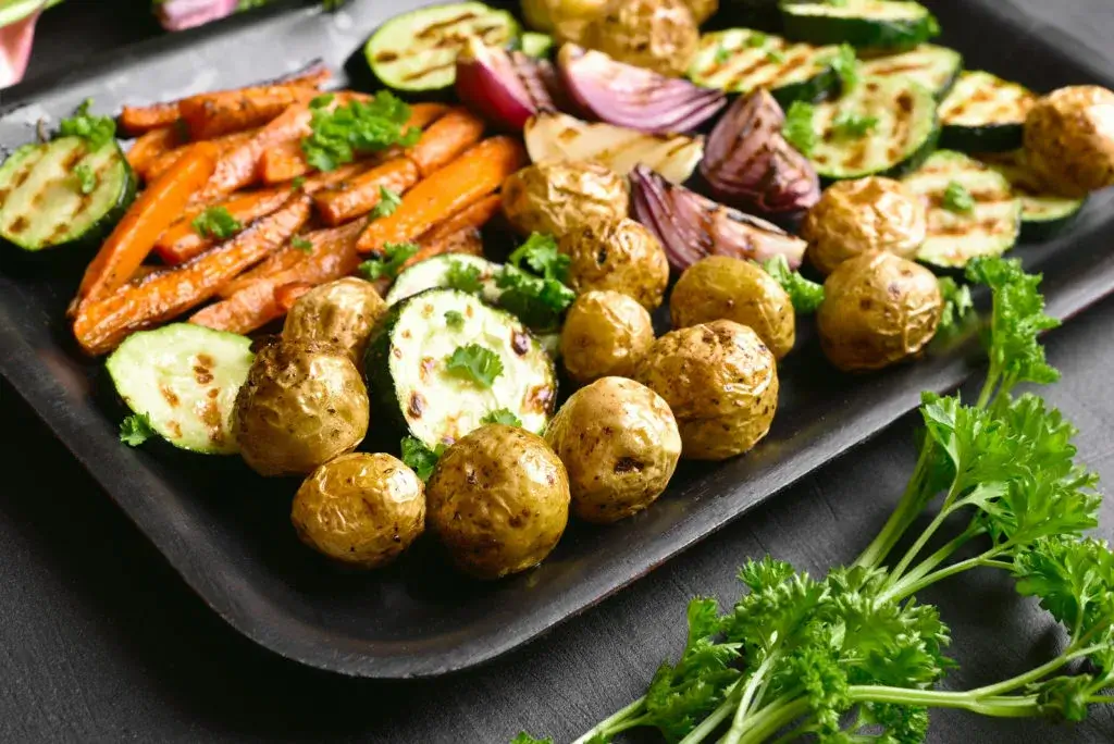 Platte mit Kartoffeln, Möhren, Zucchini und Zwiebeln