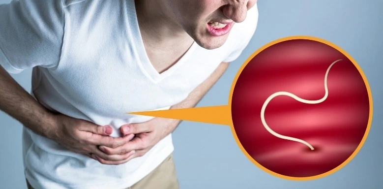 Mann greift sich an den Bauch und leidet an Schmerzen. Ein Zoom auf den Bauch zeigt einen Parasiten
