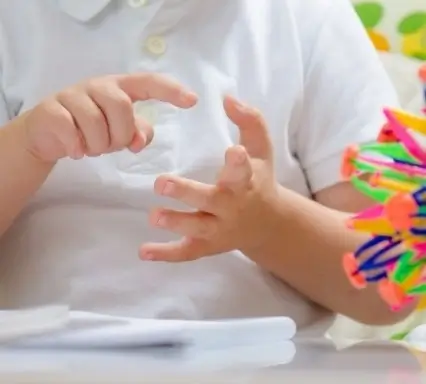 Ein Kind zählt mit seinen Fingern als Symptom von Dyskalkulie in der Schule.