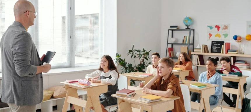 Bild eines Lehrers der vor einer Schulkasse steht