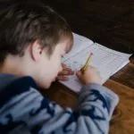 Das Kind sitzt und schreibt