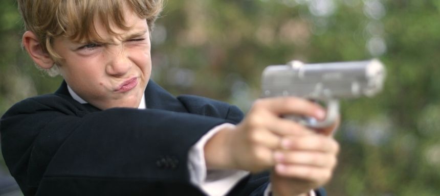 Kind als Agent zielt mit Pistole