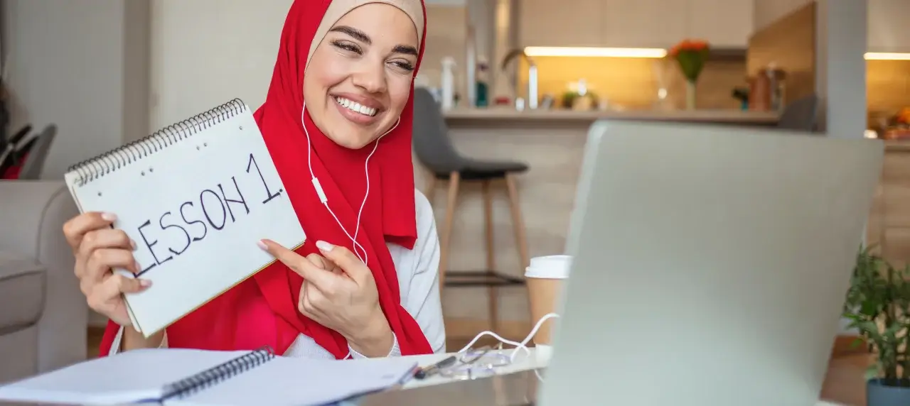 Heimunterricht Frau mit Hijab hält Lektion 1 in Kamera