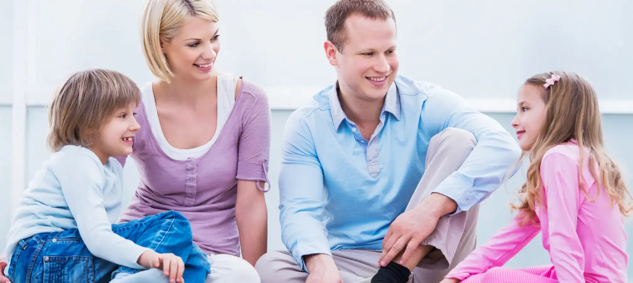 Eltern und Kind sitzen auf Couch glücklich