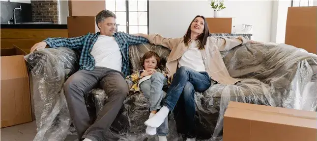 Ein ADS Kind sitzt mit seinen Eltern entspannt auf der Couch.