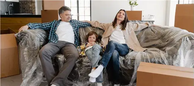 Tipps für den Umgang mit ADS Kinder Ein ADS Kind sitzt mit seinen Eltern entspannt auf der Couch.