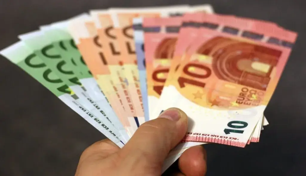 Eine Person hält mehrere Geldscheine von 10€-100€ in der Hand