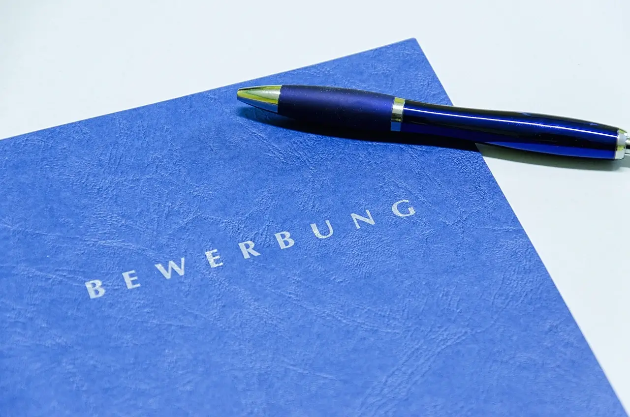 blaue Bewerbungsmappe mit einem Stift