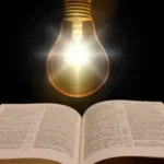 Eine Glühbirne leuchtet über einem Buch.