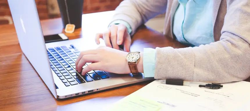 Mann schreibt seine Masterarbeit am Laptop