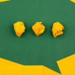Die Grundlagen der Kommunikation: Grüne Papp-Sprechblase auf gelber Pappe