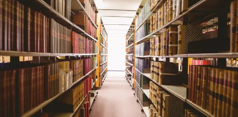 Foto aus einer Bibliothek, das einen Gang gerahmt mit Büchern darstellt