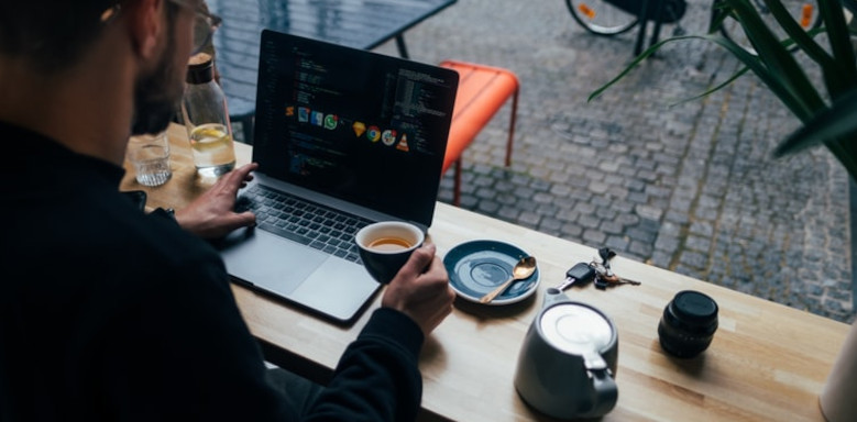 Mann mit einer Tasse Kaffee am Rechner
