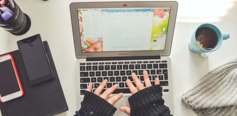 Person beim Tippen am MacBook